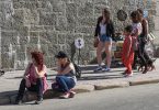 people resting in shade during hot city weather