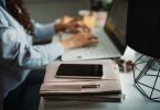 person working at desk with phone aside