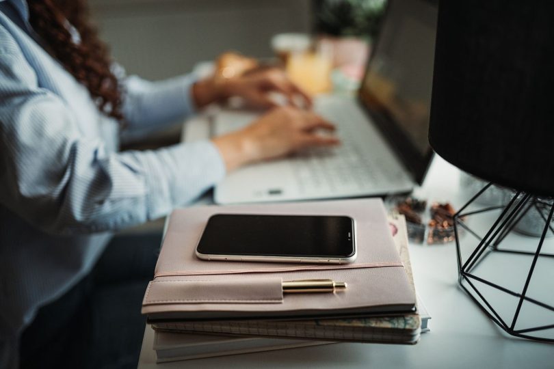 person working at desk with phone aside